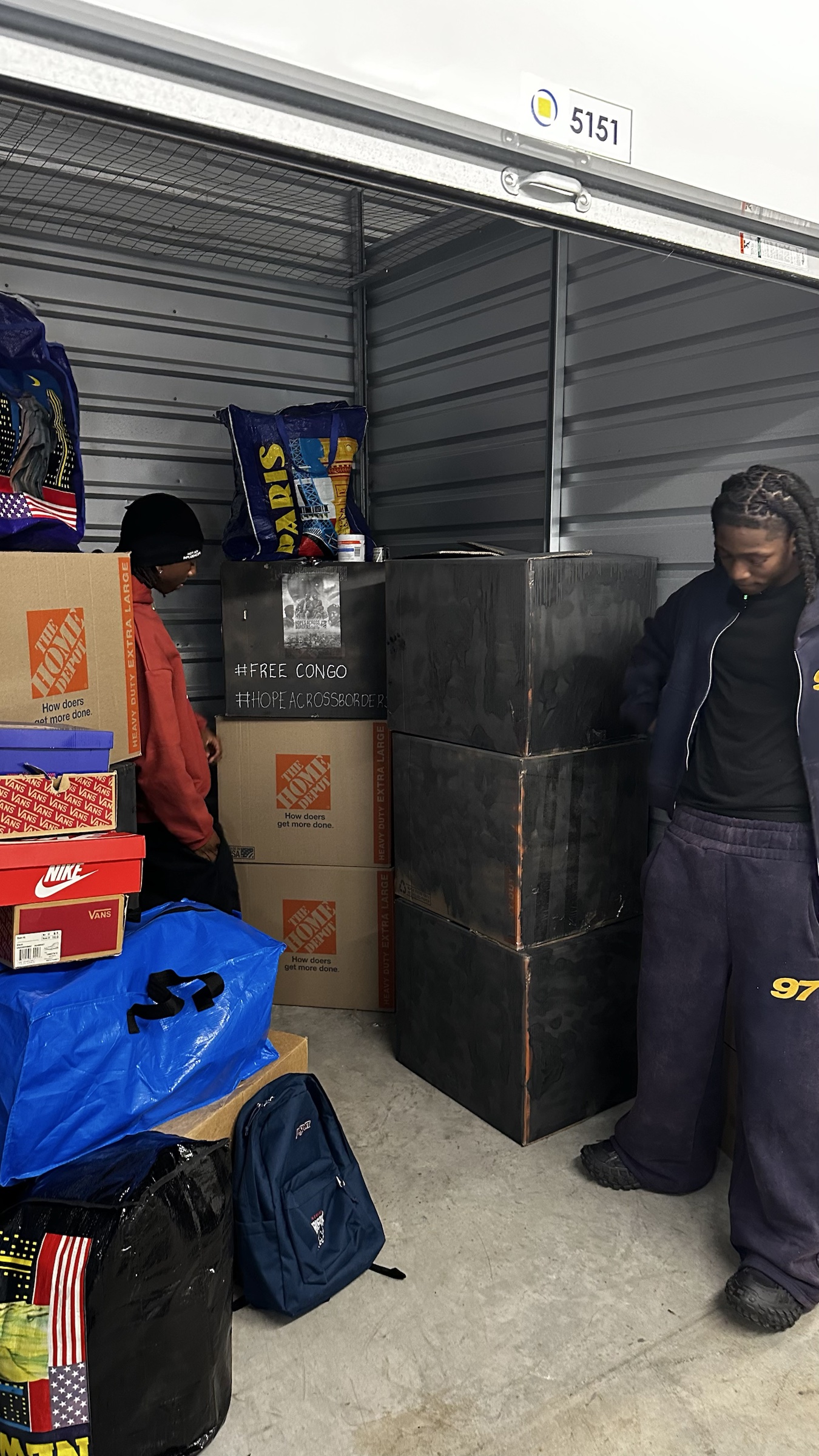 Packed shoe and clothing donations stored with Free Congo signage