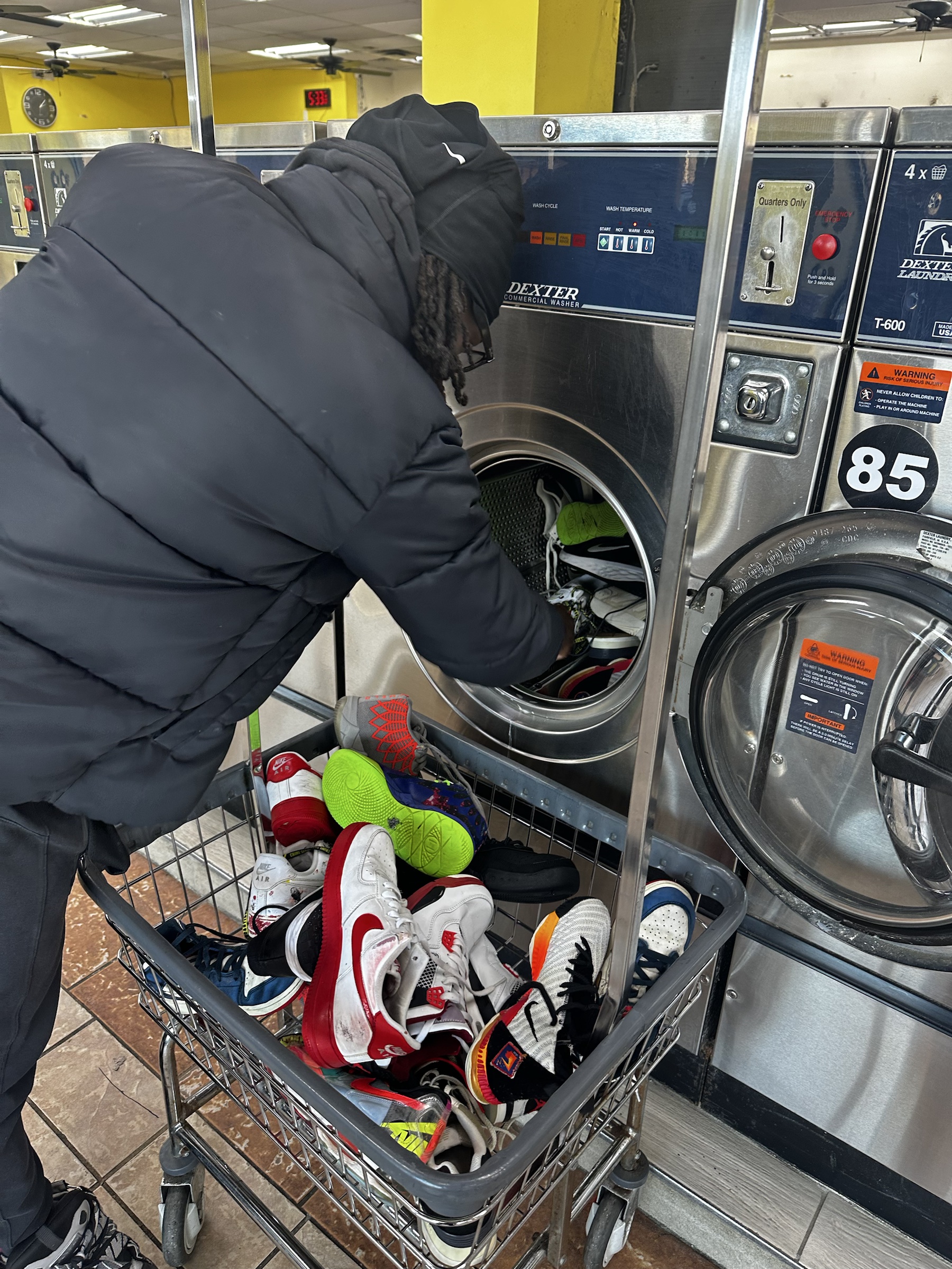 Volunteer washing donated sneakers at a laundromat