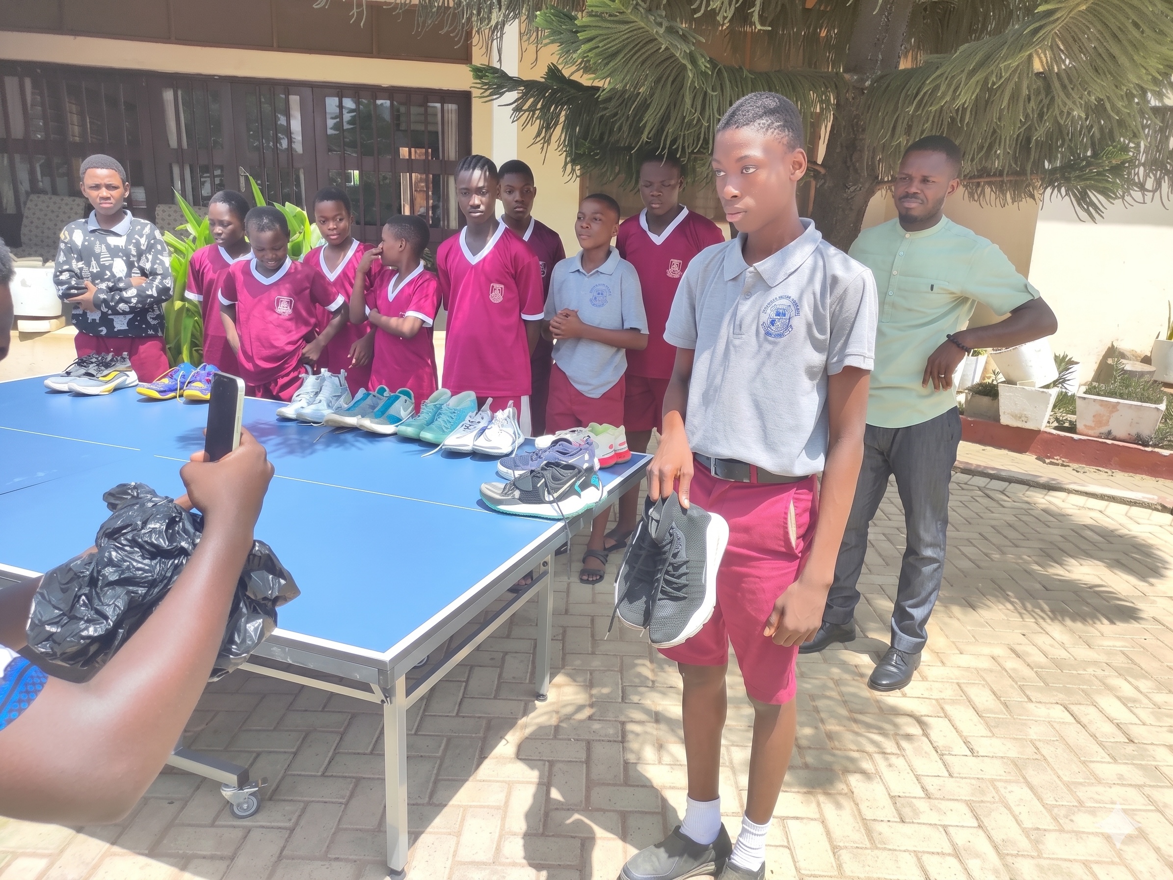 Students in Congo standing beside donated shoes