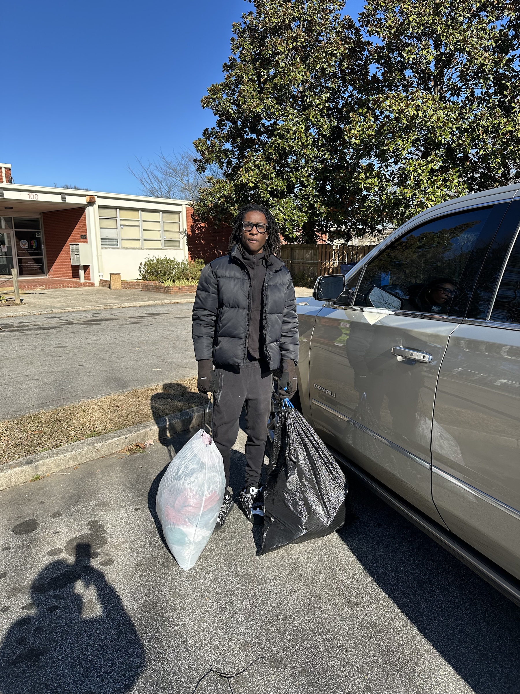 Volunteer carrying bags of donated clothing for Shoethics