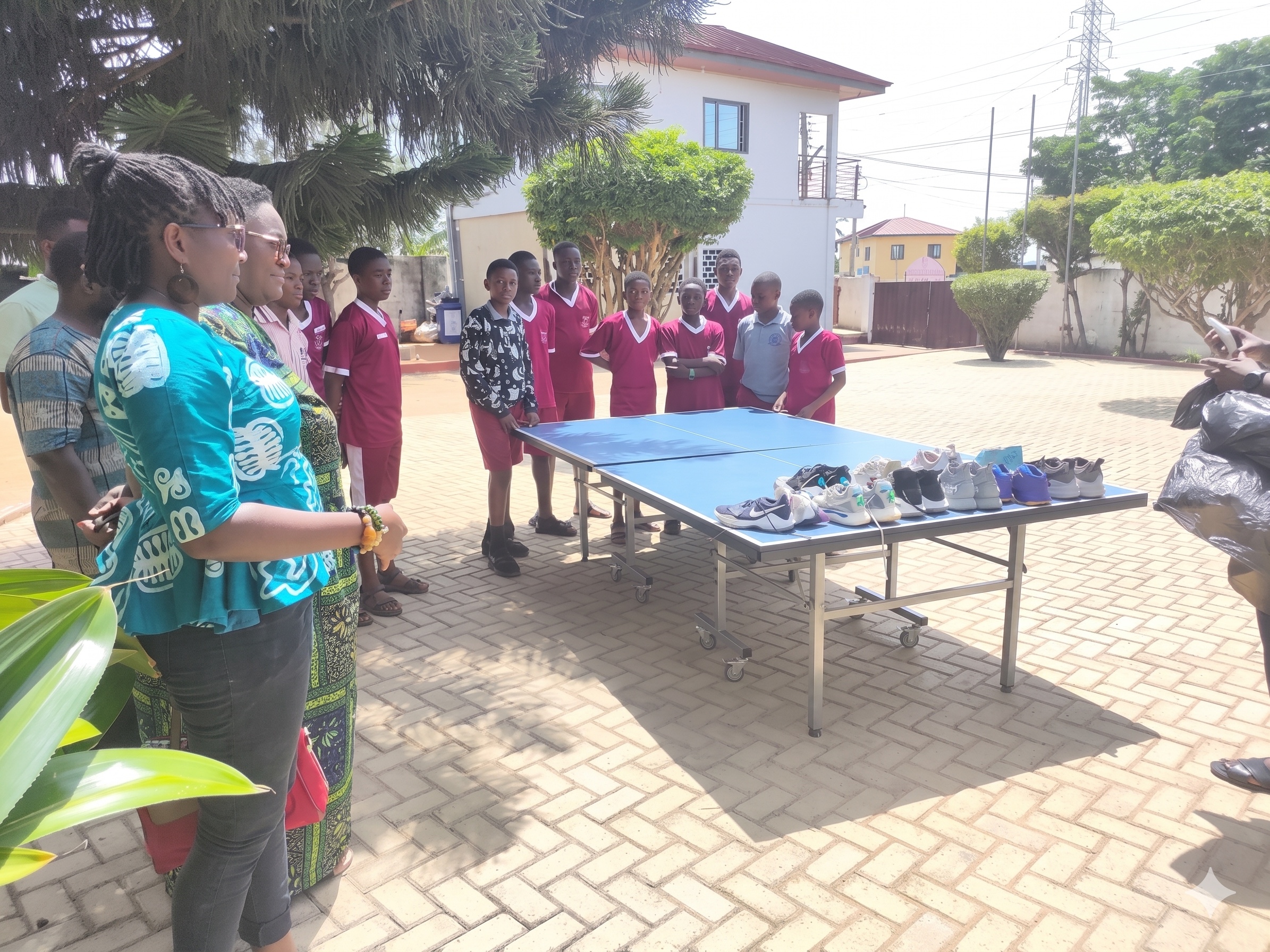 Students and staff gathered around donated shoes in Congo